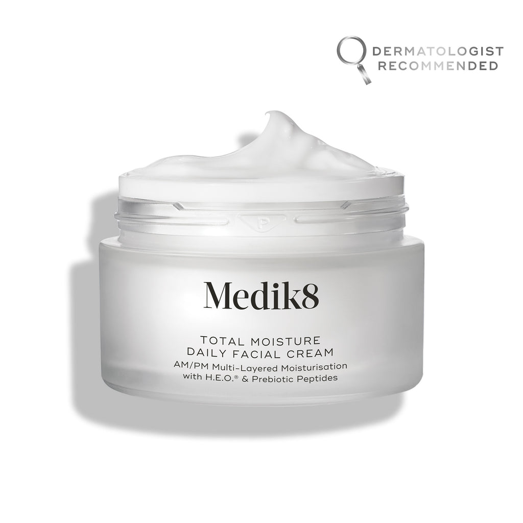 A jar of Total Moisture Daily Facial Cream™ with a "Dermatologist Recommended" stamp in the top right corner. The nourishing cream from Medik8 is labeled for AM/PM use, layered moisturization, H.E.O., and prebiotic peptides. Enhance your routine by pairing it with the C-Tetra serum for optimal results.